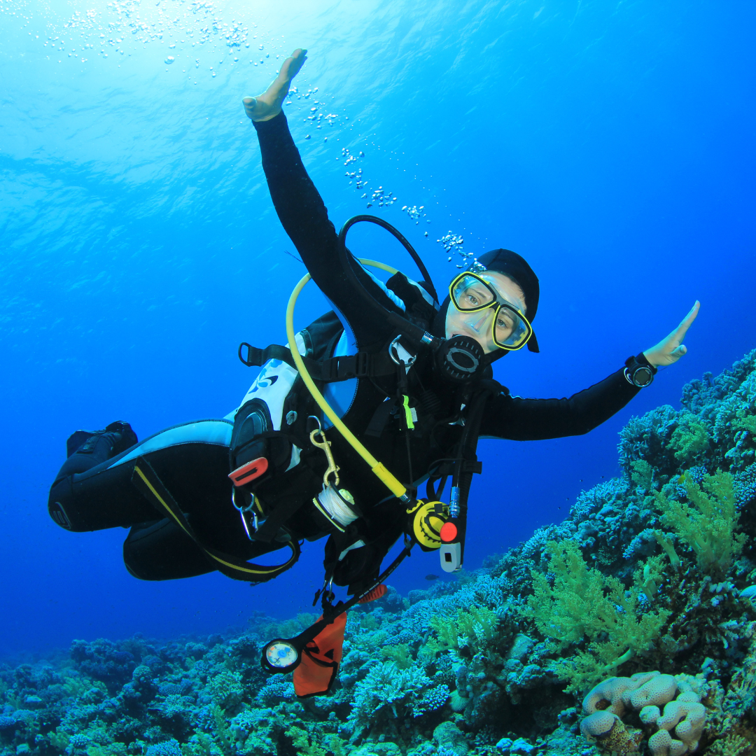 Scuba diver with arms extended underwater