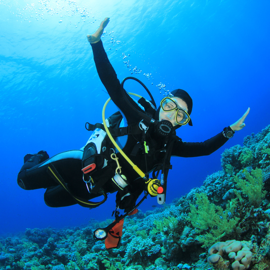 Scuba diver with arms extended underwater