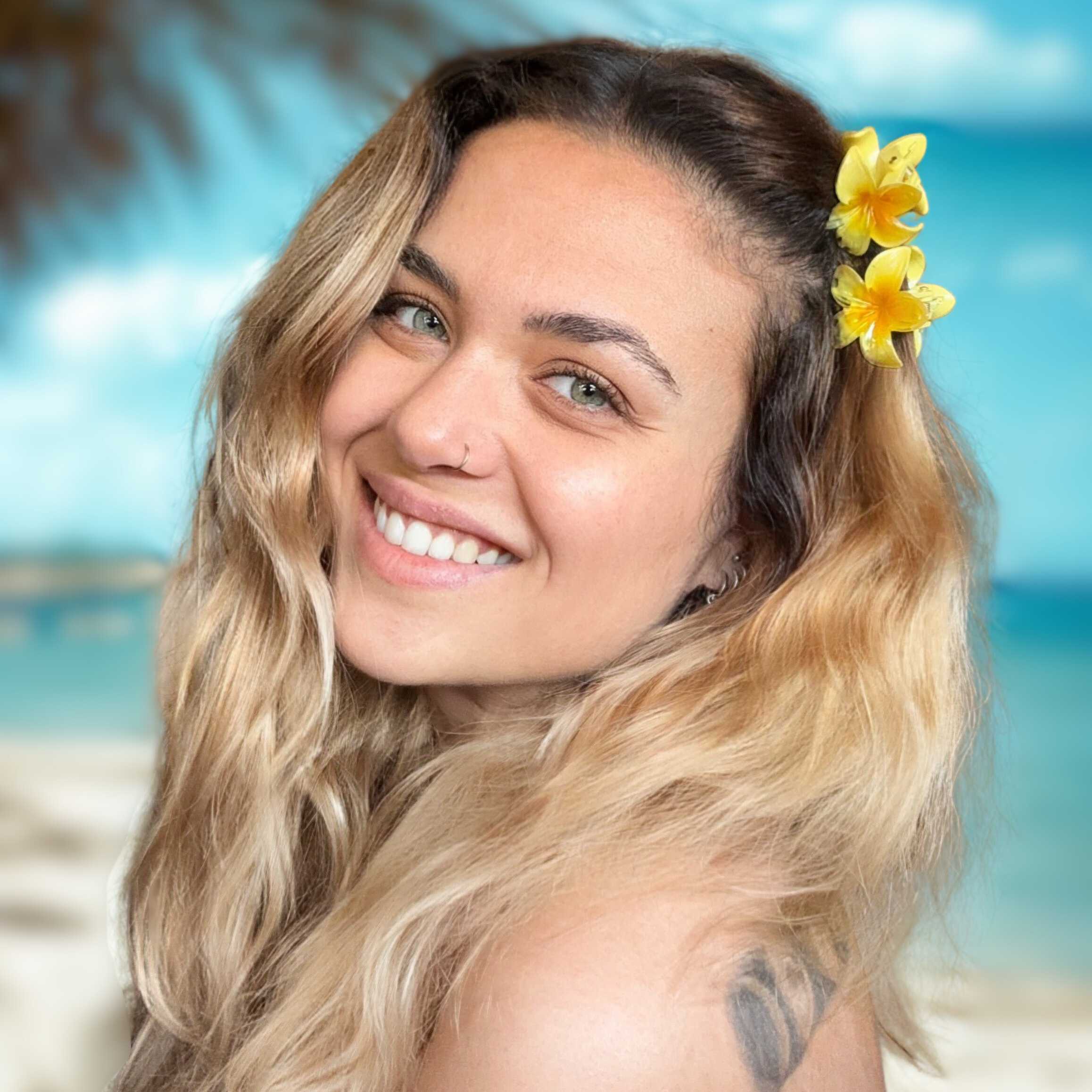 Woman with a flower in her hair smiling on a beach