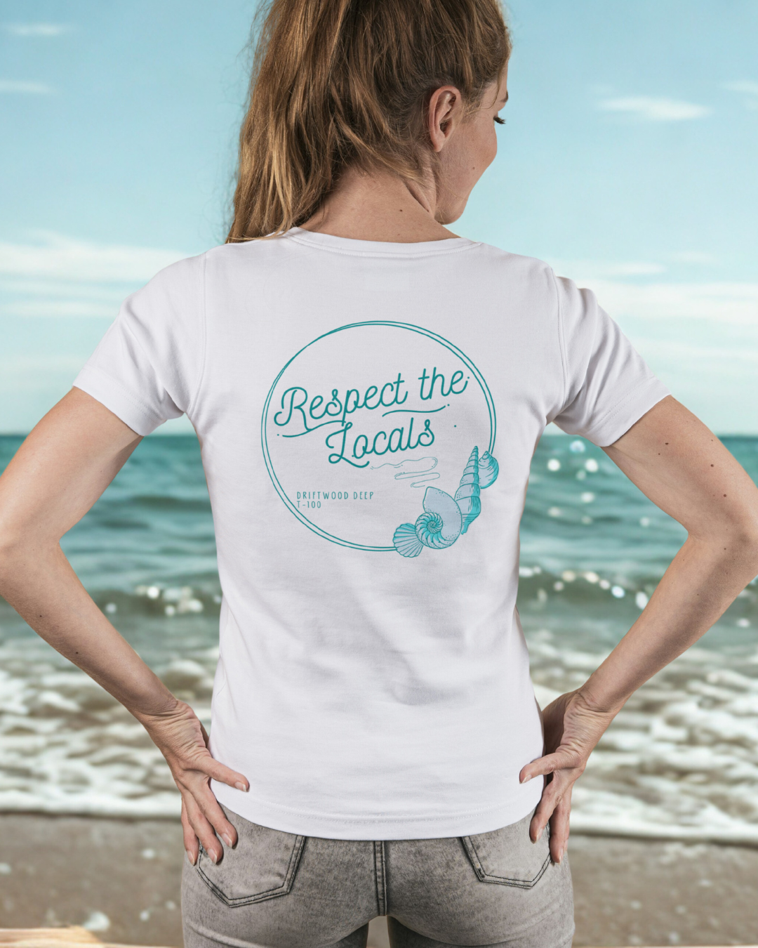 Person wearing a white t-shirt with 'Respect the Locals' text on the beach