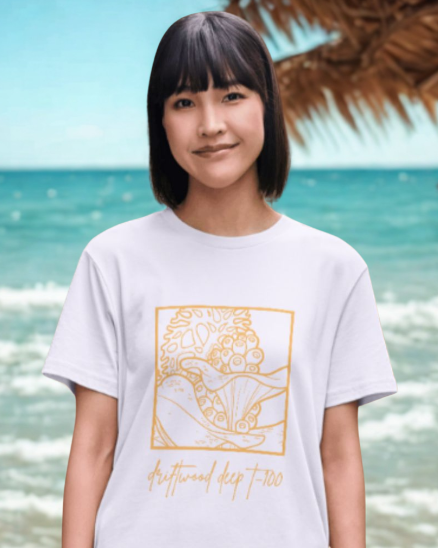 Person wearing a white t-shirt with a gold graphic design on a beach