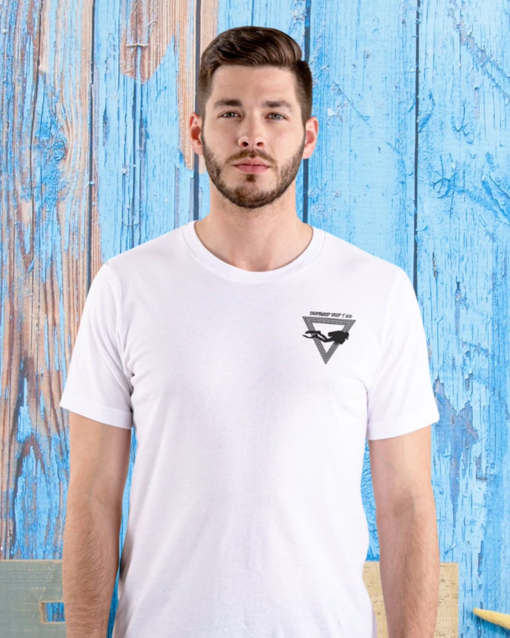 Man wearing a white t-shirt with a logo against a blue wooden background