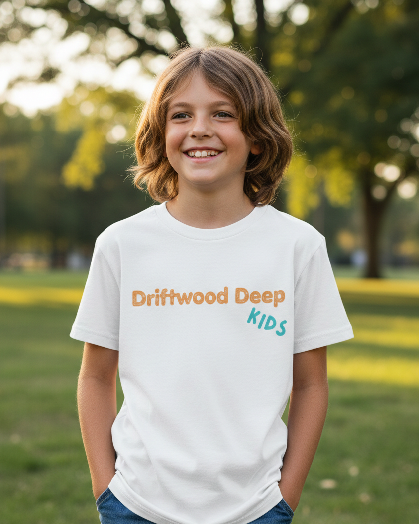 Child wearing a 'Driftwood Deep Kids' t-shirt in a park setting