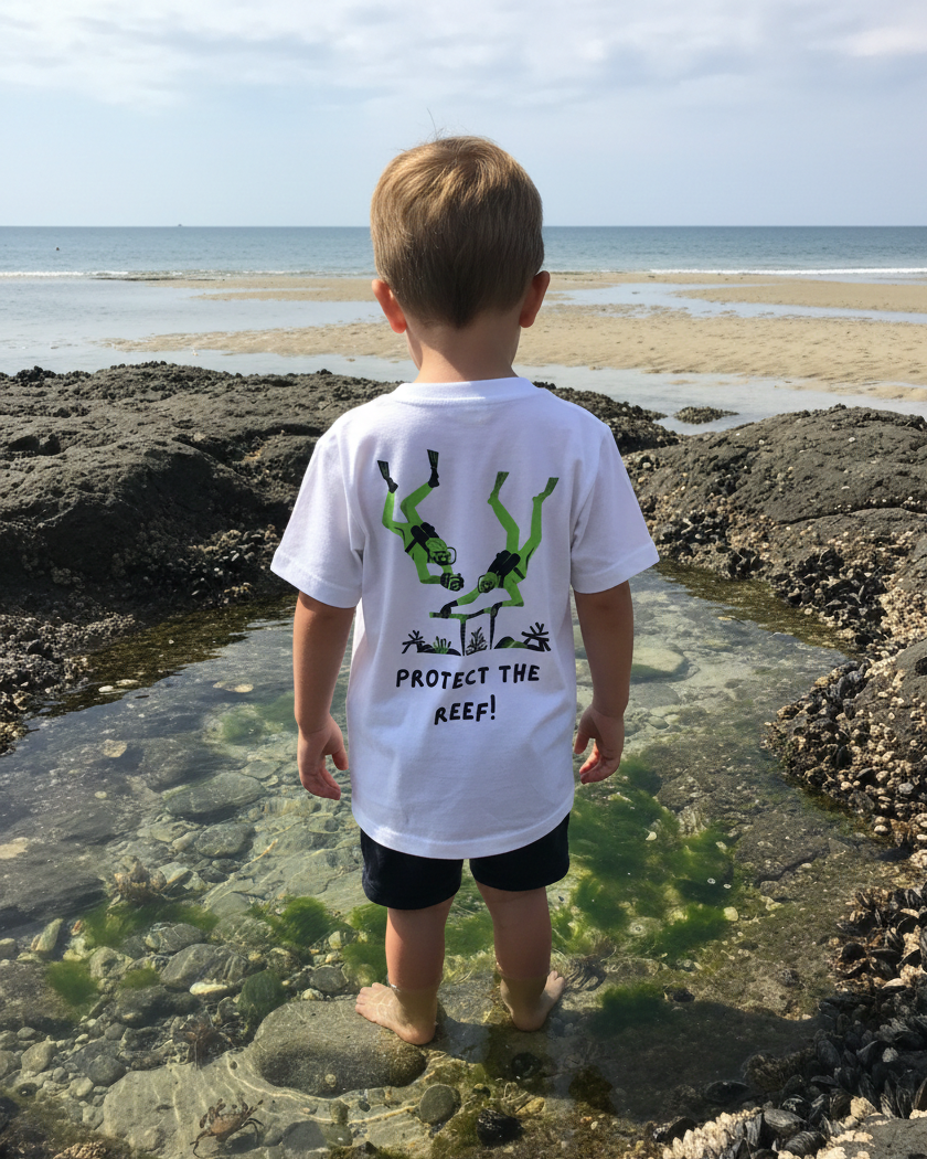 Child standing on a rocky beach wearing a shirt with an environmental message.