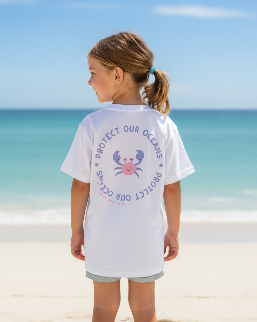 Young girl on a beach wearing a 'Protect Our Oceans' t-shirt with a crab graphic.