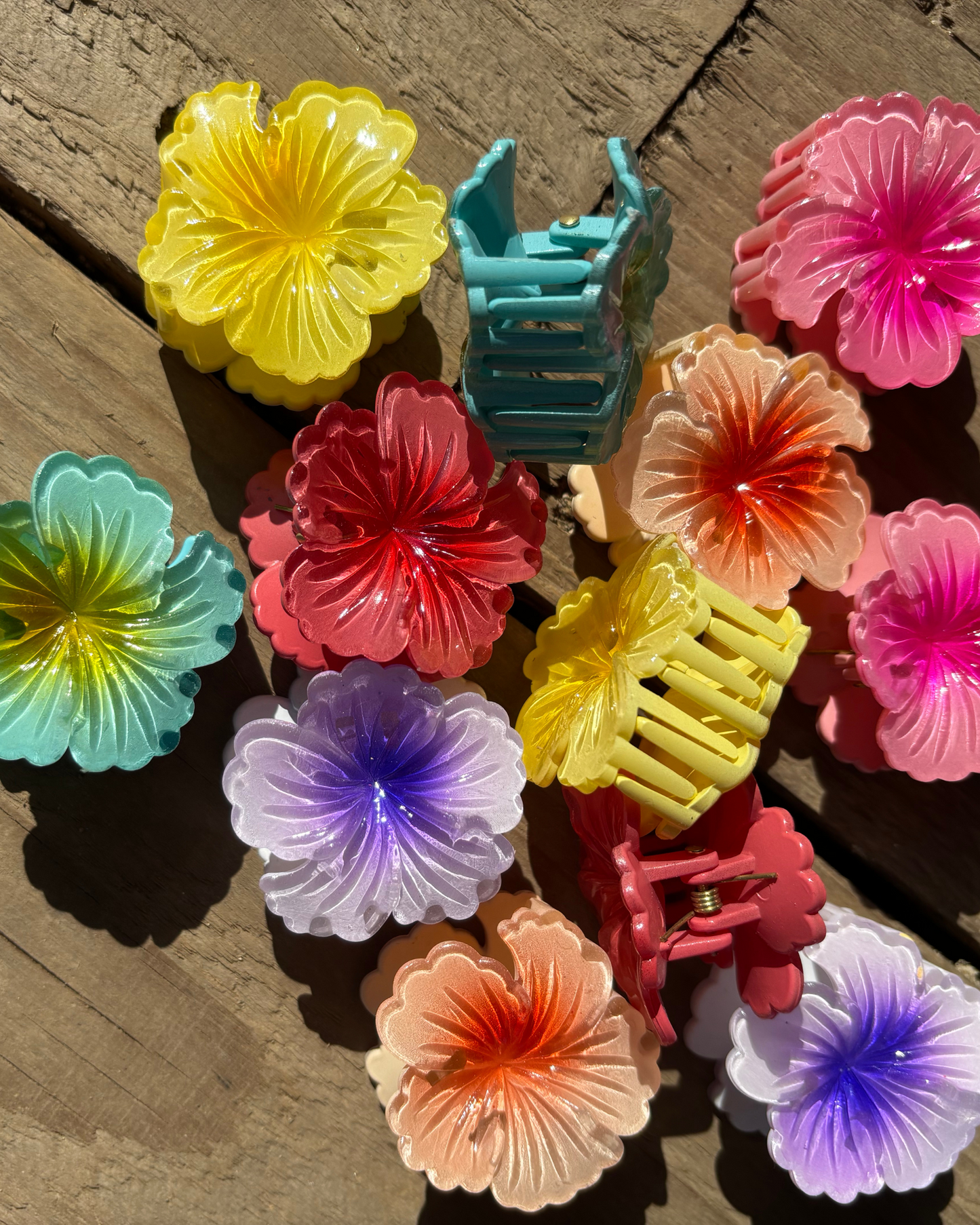 Colorful plastic flower clips on a wooden surface