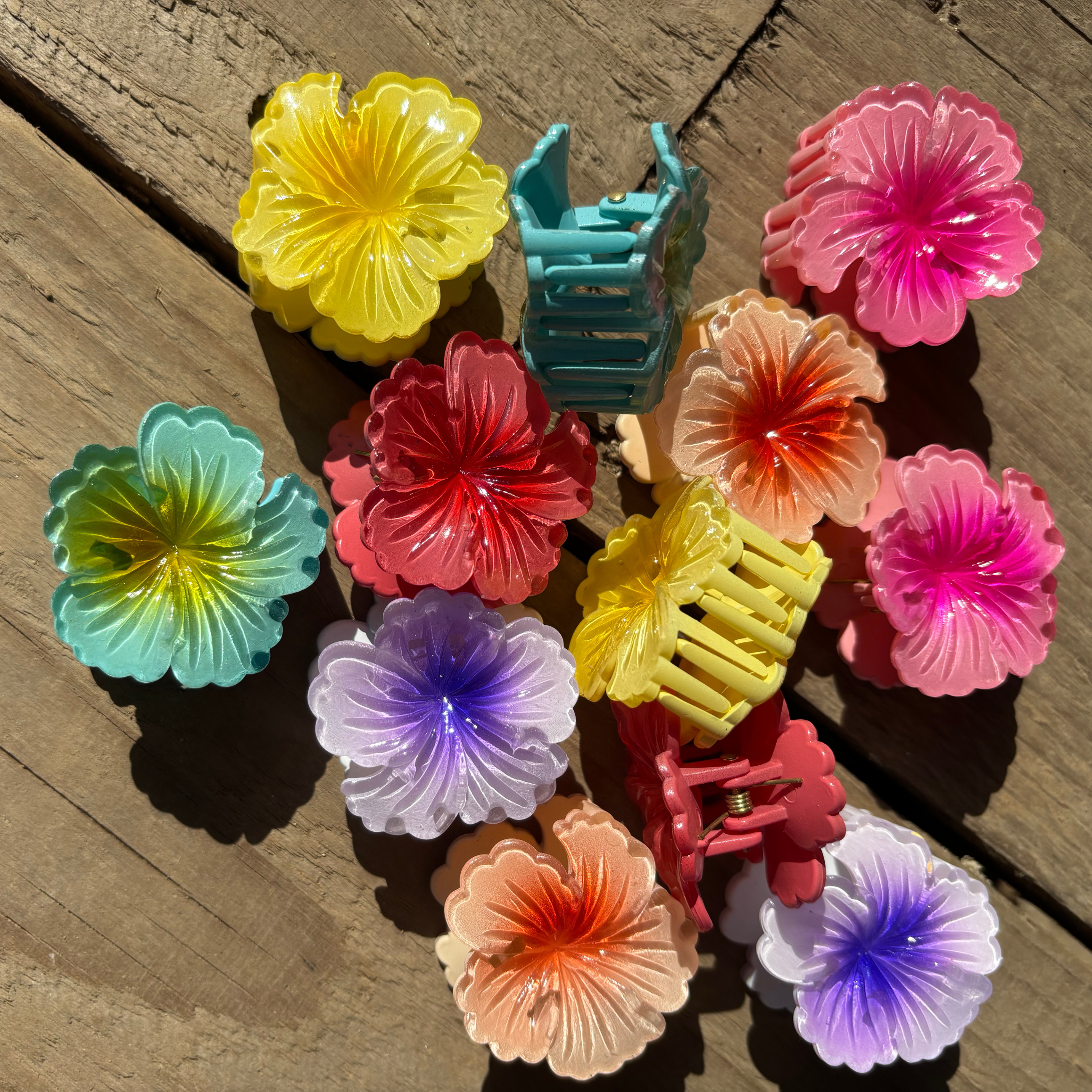 Colorful plastic flower clips on a wooden surface