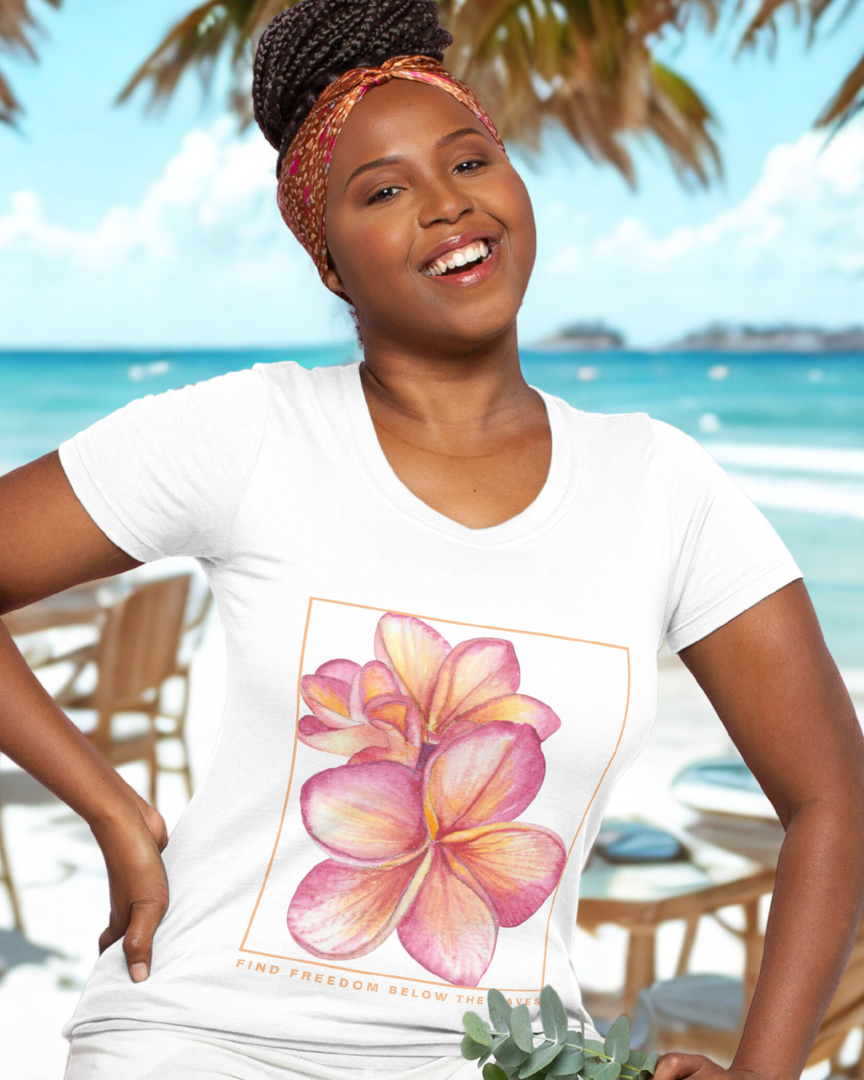 Woman wearing a white t-shirt with a pink flower design on a beach.