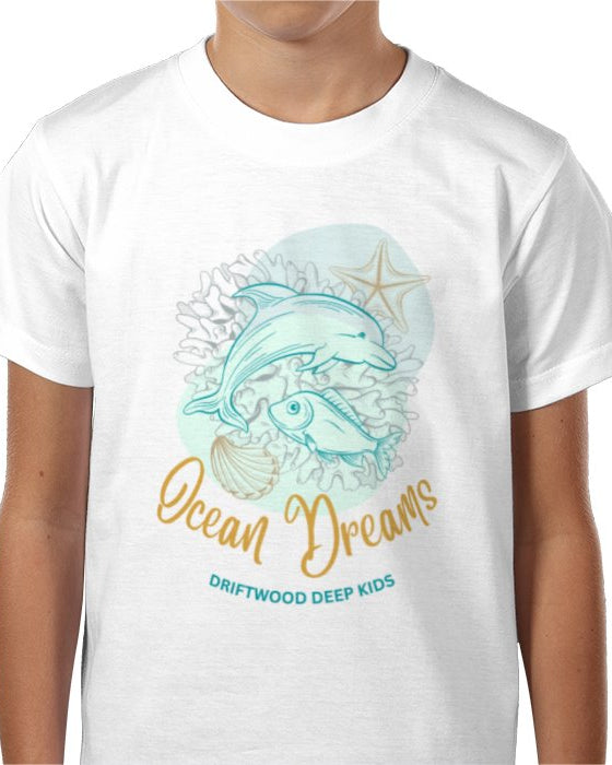 A child wearing a white T-shirt with a graphic print of a whale and accompanying sea life, and the text 'Ocean Dreams DRIFTWOOD DEEP KIDS'.