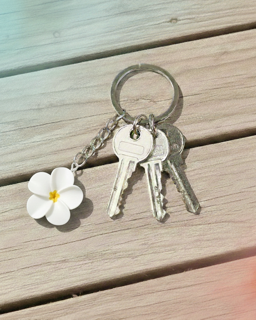 Keychain with a white flower charm on a wooden surface