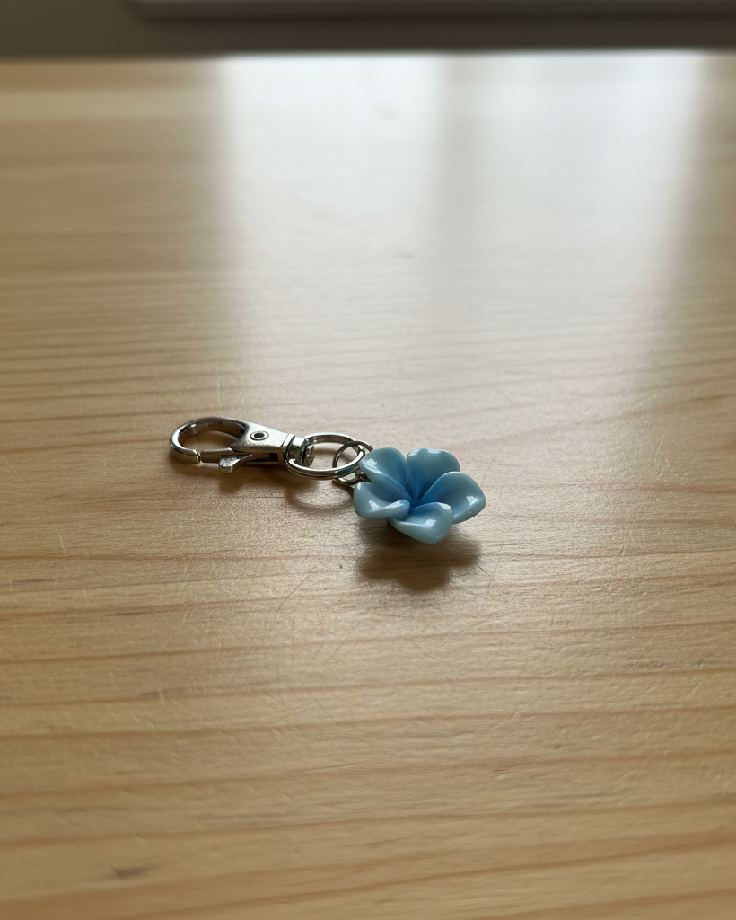 Blue flower-shaped keychain on a wooden surface