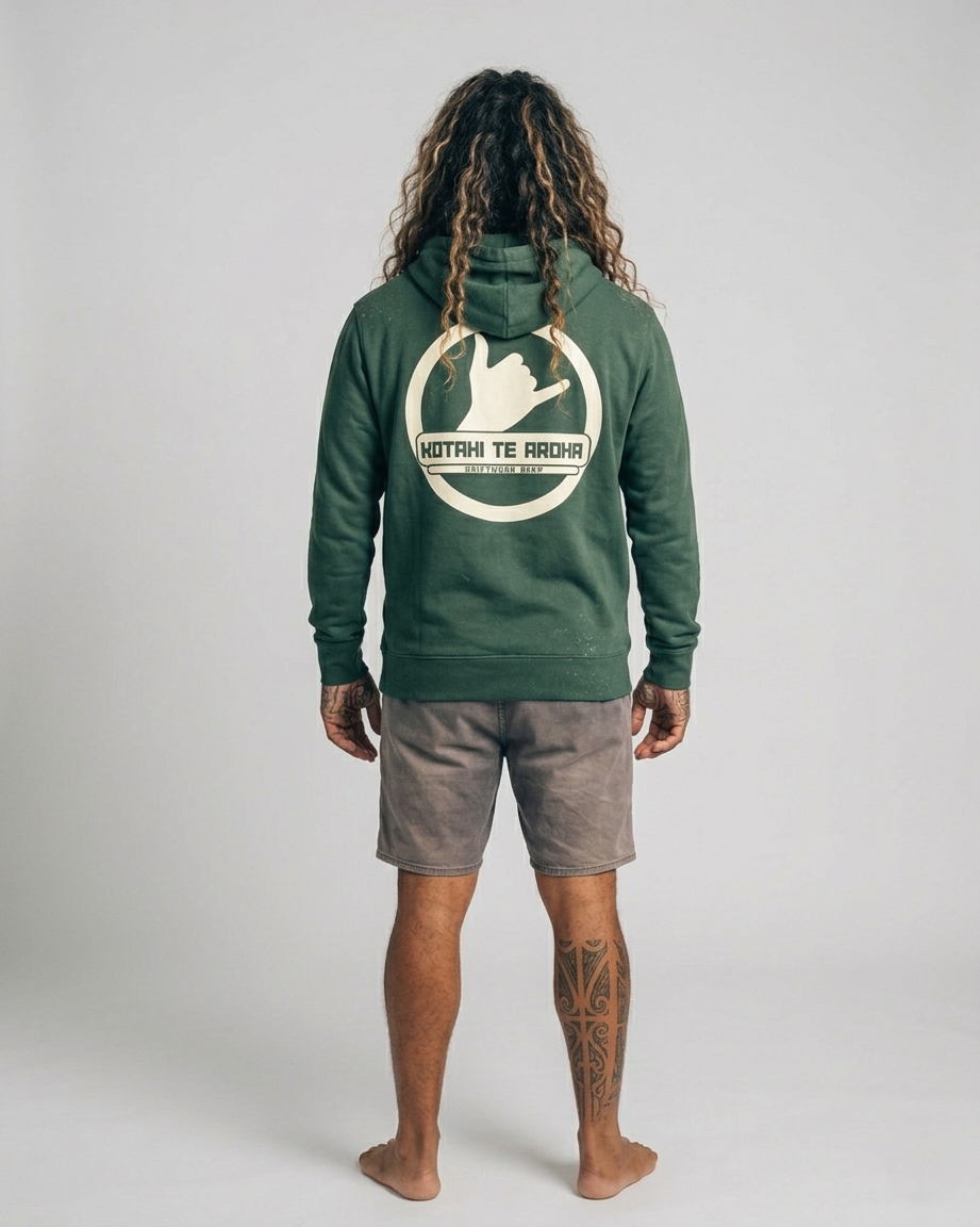 Person wearing a green hoodie with a logo on the back, standing against a plain background