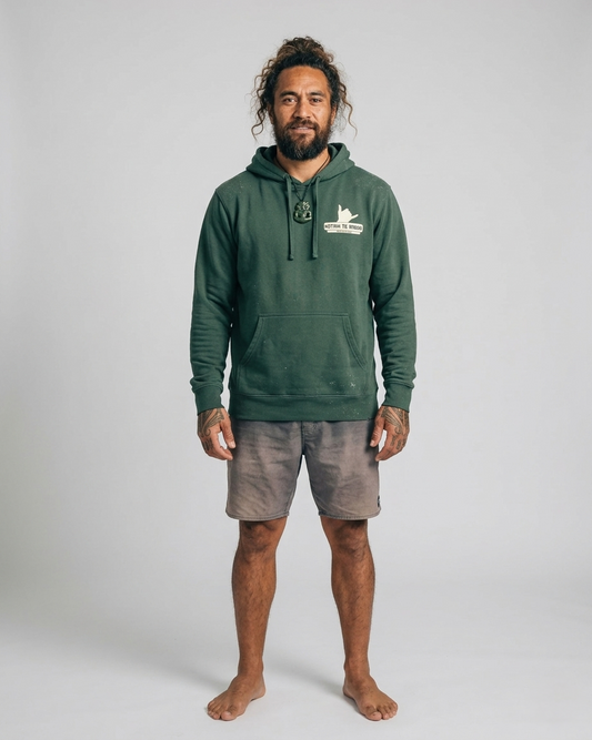 Man wearing a green hoodie with a logo on a plain background