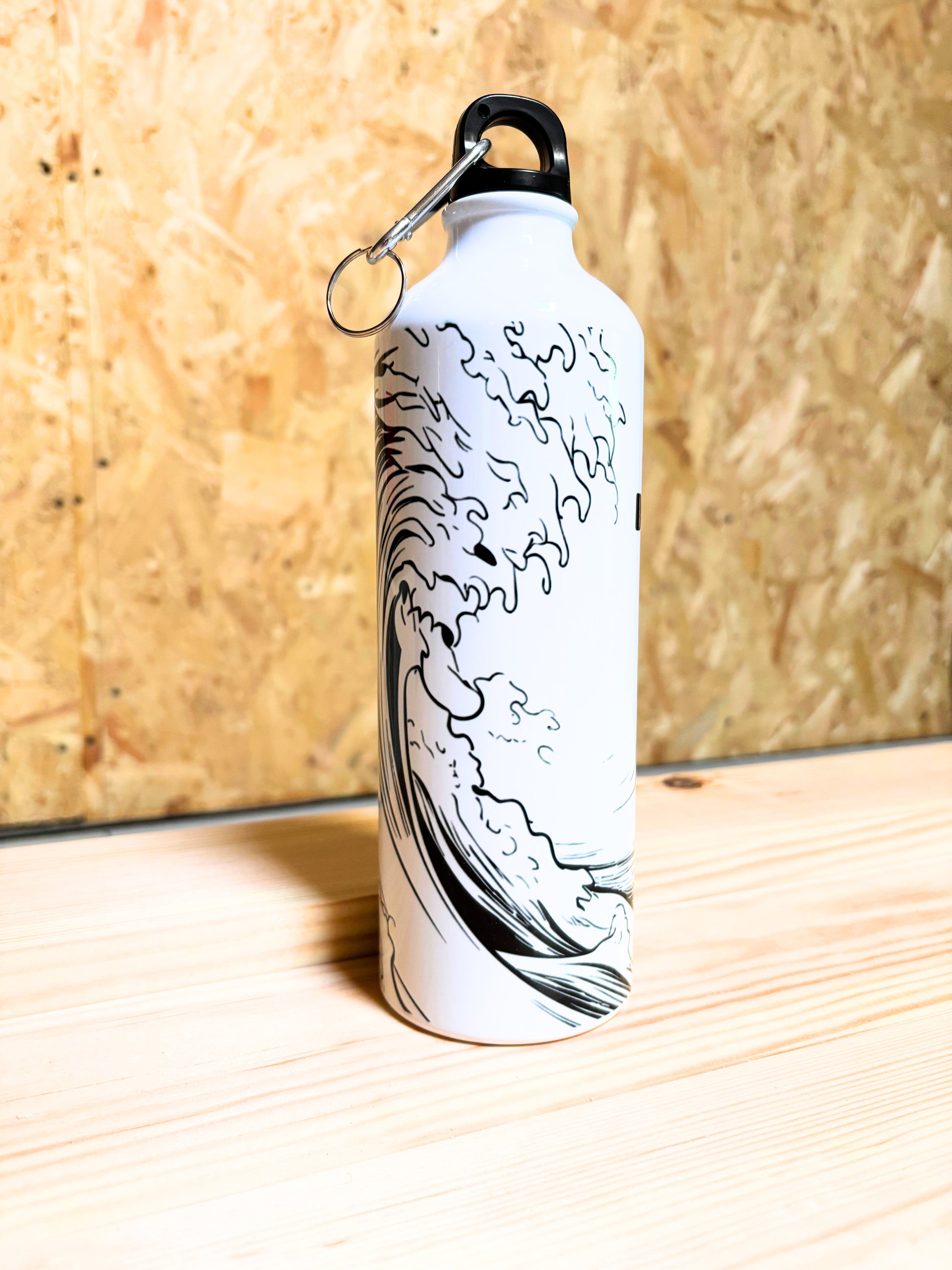 White water bottle with black wave design on a wooden surface
