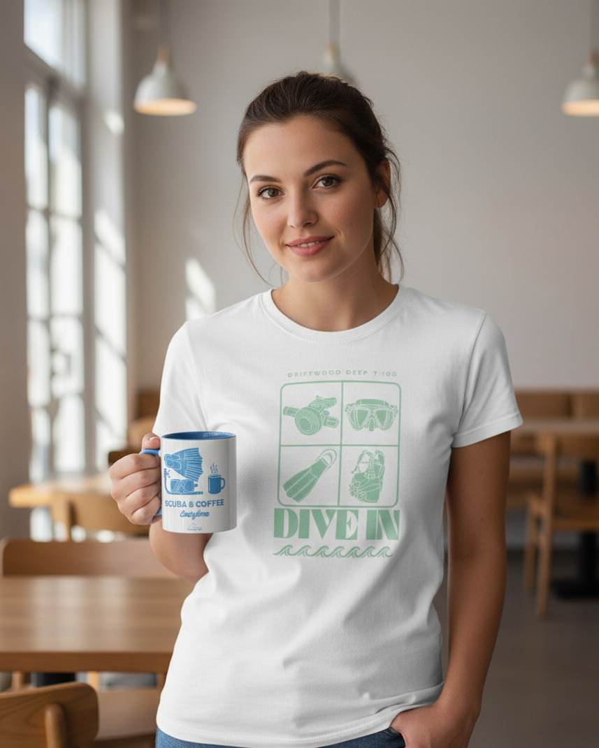 Woman wearing a white t-shirt with green graphics and text, holding a mug in a casual setting.