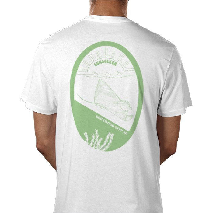 A person wearing a white crew neck t-shirt with a graphic print in the center featuring a sea-green ray and text.