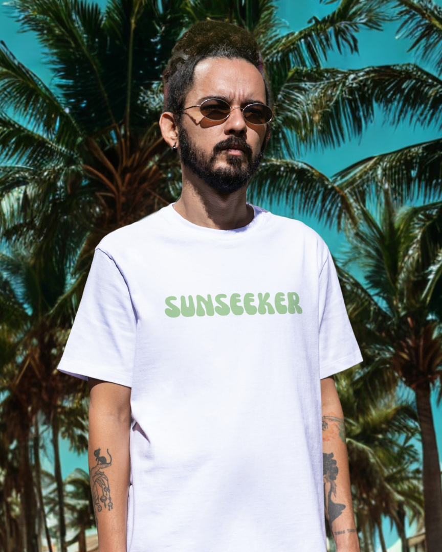 Man wearing a white t-shirt with 'Sunseeker' text in front of palm trees
