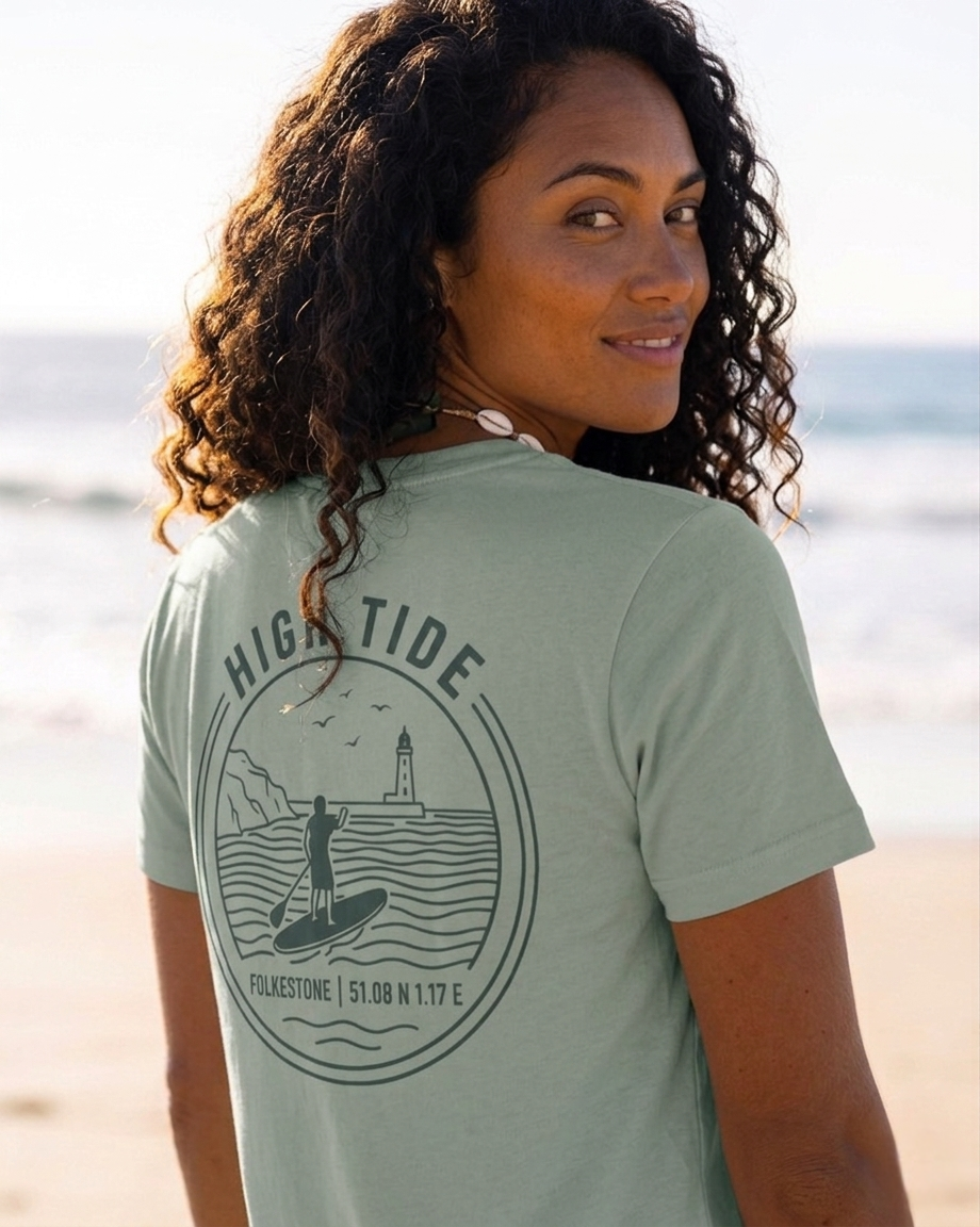 Woman wearing a green t-shirt with 'High Tide' design on a beach