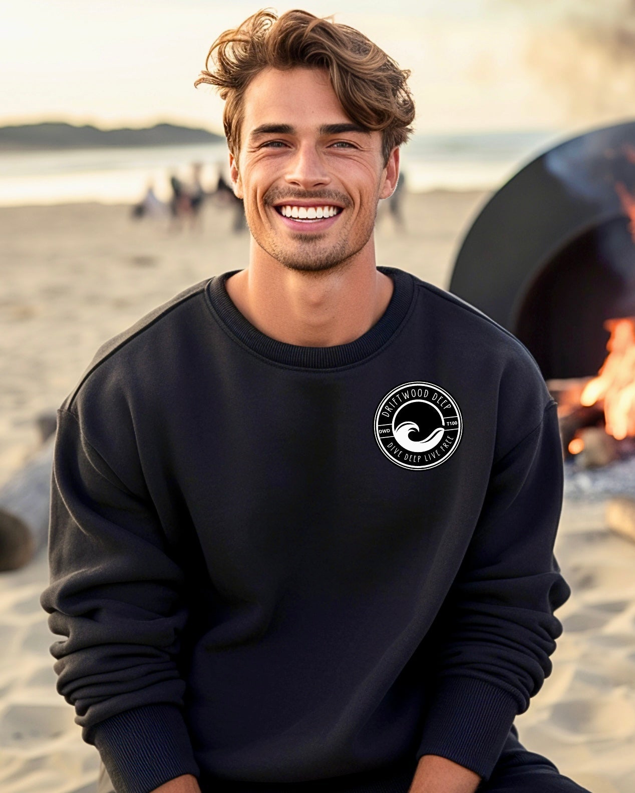 Man wearing a black sweatshirt with a logo on the beach
