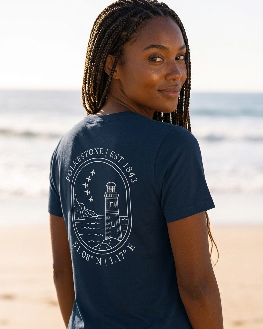 Woman wearing a navy blue t-shirt with a lighthouse design on a beach