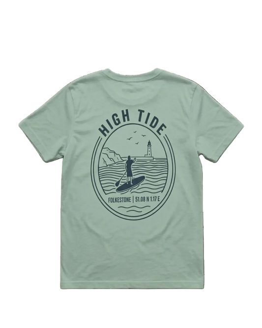 A sage green short-sleeve t-shirt shown from the back, featuring a dark teal circular graphic print with a surfer, lighthouse, and the text 'HIGH TIDE' and 'FUKESTONE | 51°00'N 1°58''.