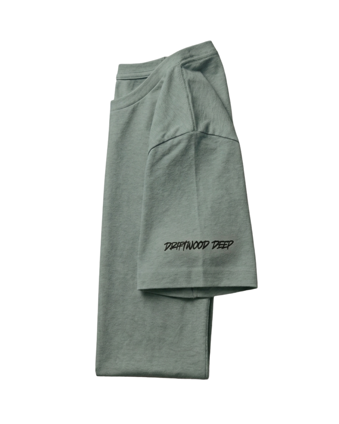 A folded sage green t-shirt with 'DRAPWOOD DEEP' printed in black script on the lower cuff, displayed on a solid white background.
