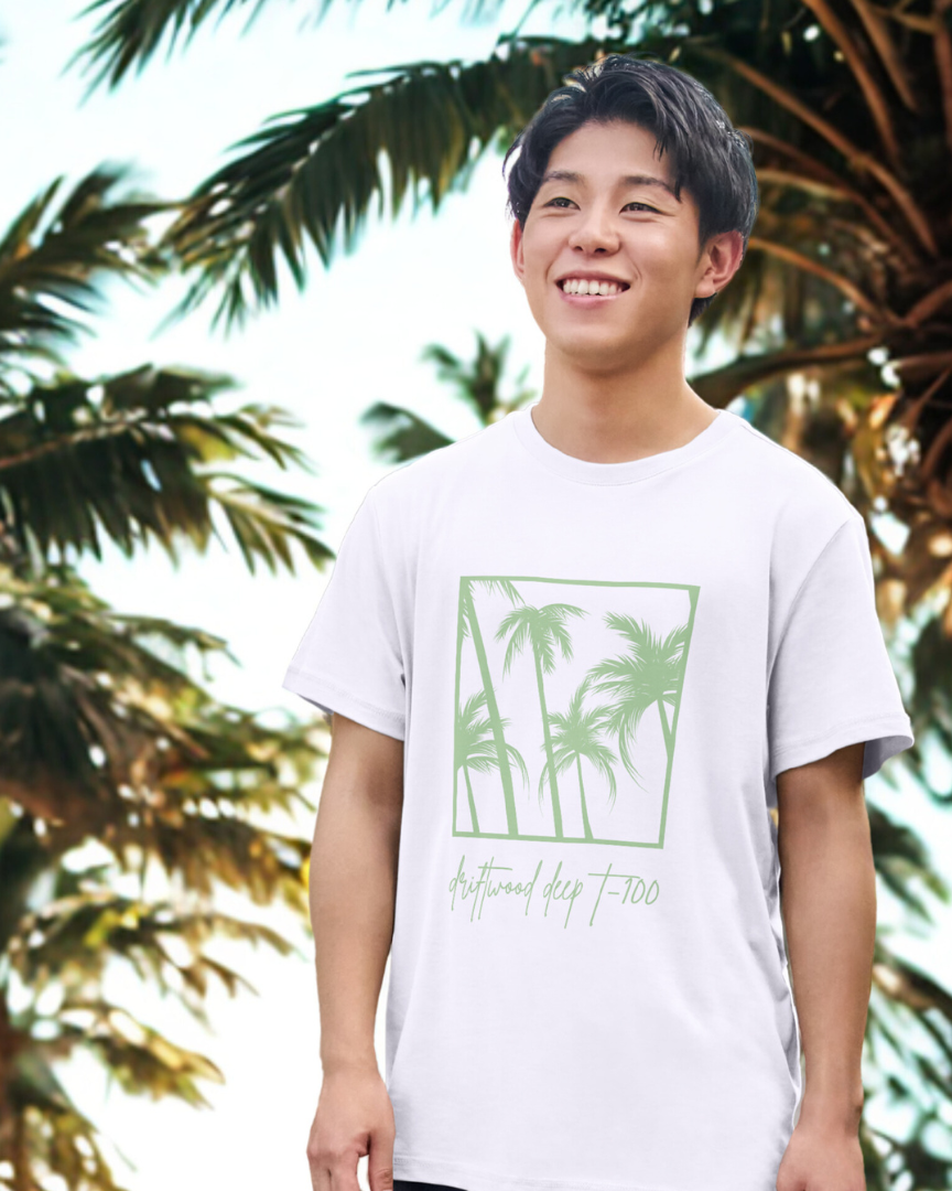 Person wearing a white t-shirt with palm tree design in front of palm trees